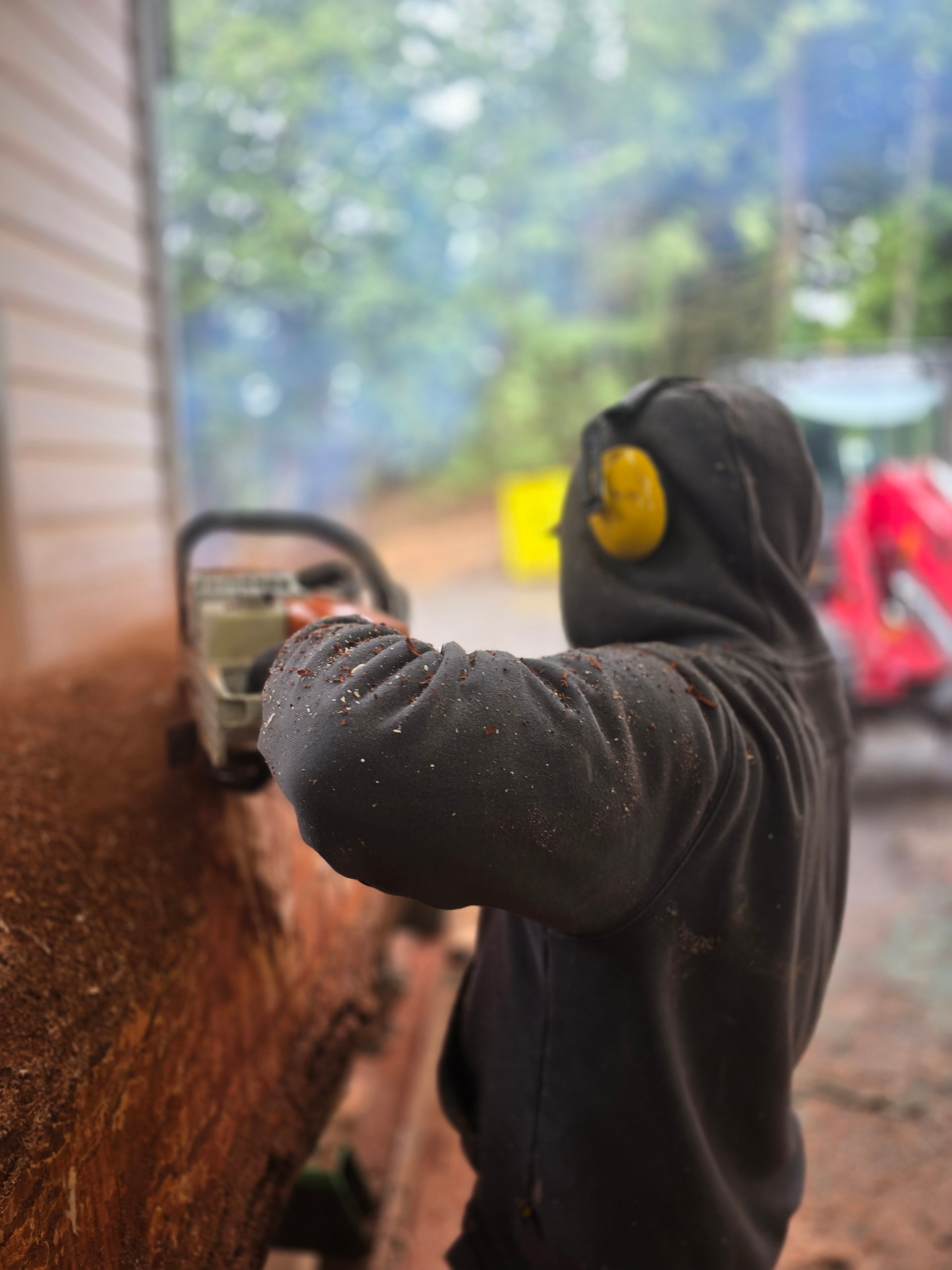 Chainsaw cutting a log with wood chips flying
